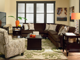 Living room with brown upholstery sectional and white chair.