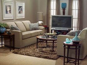 Living room with beige furniture arranged around television.